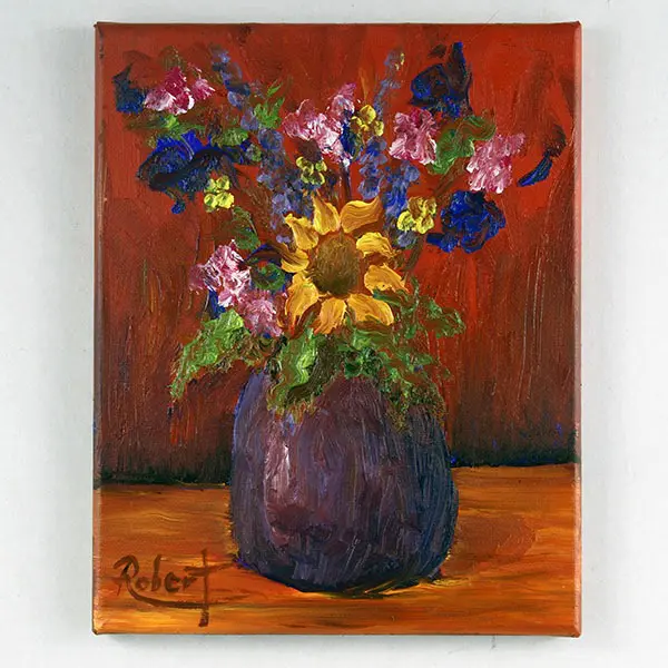 A bouquet of flowers in a purple vase with a sunflower in the center. 